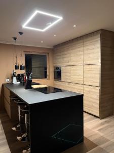 a kitchen with a black counter and wooden cabinets at Feriehus i Flekkefjord med panoramautsikt in Flekkefjord