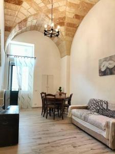ein Wohnzimmer mit einem Tisch und einem Sofa in der Unterkunft La tegola in Lecce