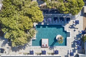 an overhead view of a swimming pool with chairs and trees at Mykonos Theoxenia Boutique Hotel in Mikonos