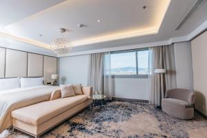a bedroom with a bed and a couch and a chair at InterContinental Barcelona by IHG in Barcelona +269 photos