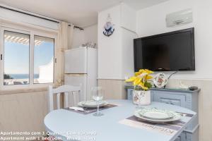 a dining room with a table and a tv at Akisol Lagos Beach in Burgau