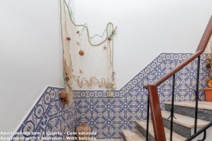 a staircase with a blue and white tiled wall at Akisol Lagos Beach in Burgau