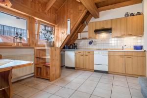 a kitchen with wooden cabinets and white appliances at Ferienwohnung Laile in Eriskirch