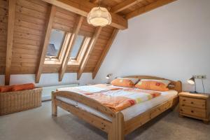 - une chambre avec un grand lit dans une pièce dotée de plafonds en bois dans l'établissement Ferienwohnung Laile, à Eriskirch