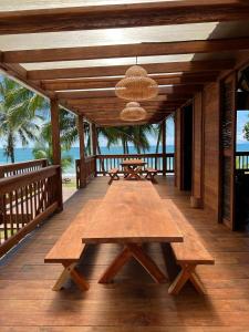 een houten tafel op een terras met uitzicht op de oceaan bij Irana Pacific Hotel in Nuquí