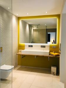 W łazience znajduje się umywalka i lustro. w obiekcie Villa Beausoleil w mieście Ramatuelle