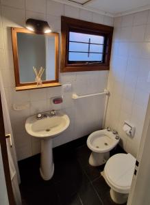 La salle de bains est pourvue d'un lavabo, de toilettes et d'une fenêtre. dans l'établissement El Cencerro Bariloche, à San Carlos de Bariloche