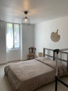 um quarto com uma cama e uma galinha na parede em L'Almanarre em Hyères