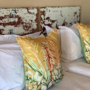 uma cama com duas almofadas em cima em The Damm House, Crystal View Vineyards 
