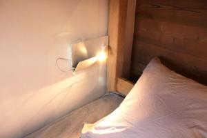 a bedroom with a bed with a light on the wall at Chalet La Plagne Montalbert Pied des Pistes in Aime-La Plagne