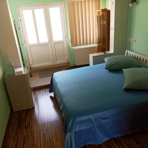 a bedroom with a blue bed and a door at Casa Victoria Anina in Anina