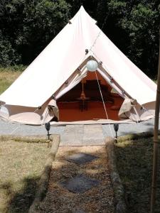 Plouray的住宿－tente insolite 1 à 5 personnes，草上带桌子的白色帐篷