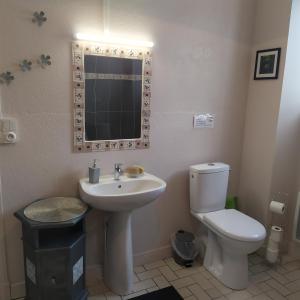 Un baño con lavabo, inodoro y espejo. en Au doux refuge, en Saint-Exupéry-les-Roches 20 fotos más