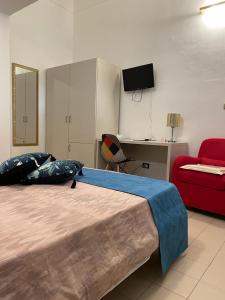 una camera con un grande letto e un divano rosso di Albergo Bouganville a Favignana