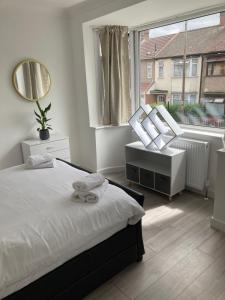 a bedroom with a bed and a large window at Gresham Home - close to ExCel, contractors, relocators, paid parking in London