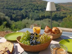 a table with baskets of grapes and bread and a glass of orange juice at Tuffudesu Experience in Osilo