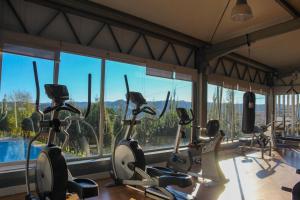 a gym with cardio machines in front of a window at Coimbra Camping & Bungalows in Coimbra