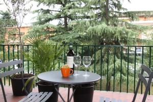 una mesa con 2 copas de vino en el balcón en Terrazze Fiorite, en Bérgamo