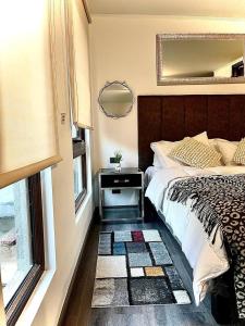 a bedroom with a bed and a mirror and a window at Apart Hotel in downtown Santiago Historic Center in Santiago