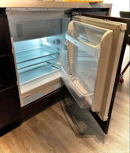 an empty refrigerator with its door open in a kitchen at Apart Hotel in downtown Santiago Historic Center in Santiago