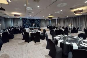 a banquet hall with tables and chairs in a room at Village Hotel Edinburgh in Edinburgh