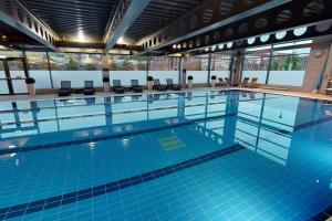 a large swimming pool with blue tiles in a building at Village Hotel Edinburgh in Edinburgh