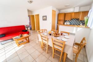 sala de estar con mesa y sofá rojo en Les Chalets de la Vallee du Bes, en Noalhac