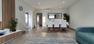 阿爾布費拉的住宿－Beach View Vela House，客厅配有白色桌子和蓝色沙发