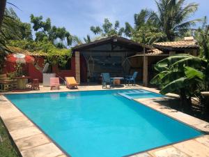 a swimming pool in a yard with a house at Guest House Lua in Paracuru