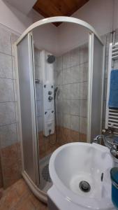 La salle de bains est pourvue d'une douche et d'un lavabo blanc. dans l'établissement Ioannis - Zimmer mit Zugang zu Terrasse, à Gavrolímni