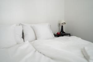twee witte bedden met kussens en een lamp op een tafel bij King Seventeen Homes in Boedapest