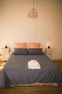 a bedroom with a blue bed with a towel on it at ENTRE PIERRE ET BOIS in Saint-Savinien