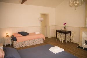 a room with two beds and a table with a desk at ENTRE PIERRE ET BOIS in Saint-Savinien