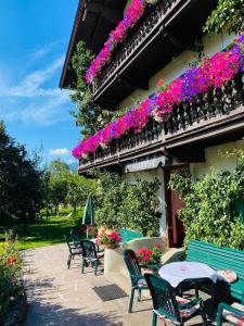 un patio con sillas, mesas y flores en Pension Rainhof, en Kitzbühel