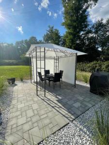 a gazebo with a table and chairs under it at Beds Friends Apartments in Zator