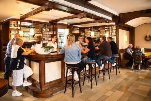 grupa ludzi siedzących w barze w restauracji w obiekcie Landhotel Hopster w mieście Rheine