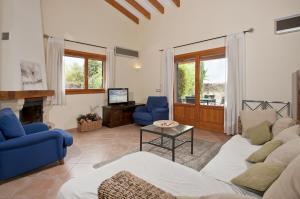 a living room with a couch and chairs and a tv at Ubac Pollença in Sa Pobla