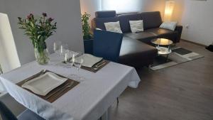 - un salon avec une table, des verres à vin et un canapé dans l'établissement Modernes Apartment in Minden am Hauptbahnhof, à Minden