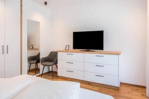 a bedroom with a white dresser with a television on it at Luisl Hof - Apartment Vitis in Cornaiano