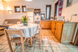 - une cuisine et une salle à manger avec une table et des chaises dans l'établissement Village de Gîtes de Chateauneuf de Randon, à Châteauneuf-de-Randon