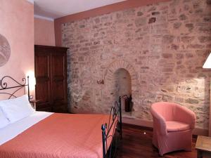 1 dormitorio con 1 cama y 1 silla en La Luna nel Borgo en Spello