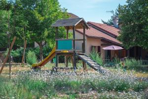 a playground with a slide in a garden at Villages de Gîtes Le Pigeonnier in Le Malzieu-Ville
