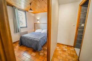 a bedroom with a bed and a mirror at Villages de Gîtes Le Pigeonnier in Le Malzieu-Ville