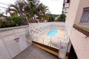 einen Außenblick auf einen Balkon mit Pool in der Unterkunft Casa Guarujá - Condomínio in Guarujá