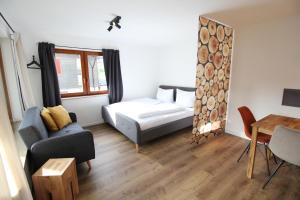 Ferienwohnung im Zentrum von Oberstaufen في اوبرستوفن: غرفة معيشة صغيرة مع سرير وطاولة