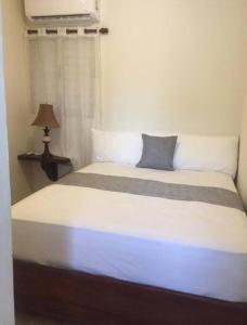 a bedroom with a bed with a blue pillow on it at Apartamento JM. in San Felipe de Puerto Plata