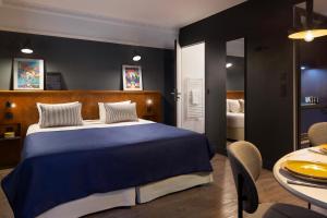 a bedroom with a blue bed and a table at Appartements RockyPop Grenoble in Grenoble +35 photos