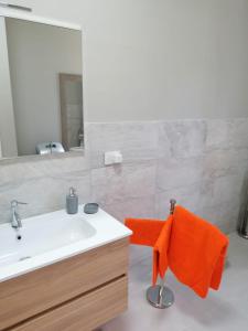 a bathroom with a sink and a mirror and orange towel at Sea 1 in Civitanova Marche