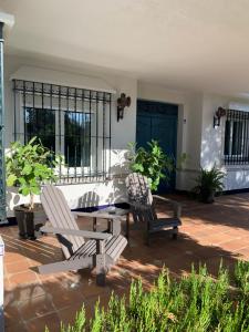 dwa krzesła i stół na patio w obiekcie Casa Ciaurriz w mieście Mairena del Aljarafe
