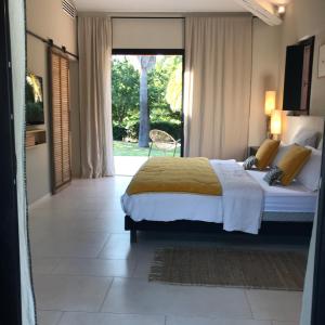 sypialnia z łóżkiem i dużym oknem w obiekcie Villa Beausoleil w mieście Ramatuelle
